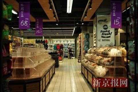 北京/东湖渠附近的乐天超市内，工作人员放置价格表。