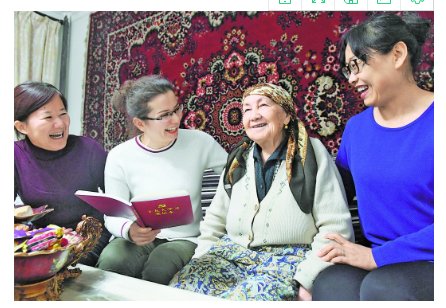 周涛/12月15日，周涛的同事为热娜汗大妈宣讲十九大精神。
