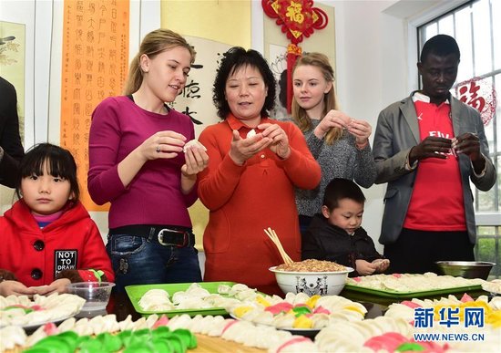 合肥/12月21日，外国留学生与科企社区居民一起包饺子。