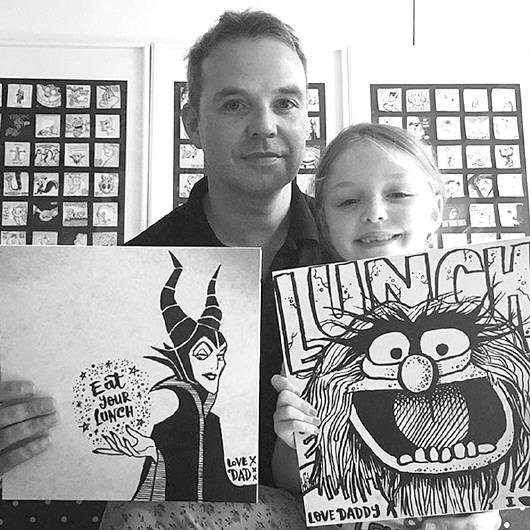 漫画 罗布/罗布和女儿拿着他画的“午餐漫画”。