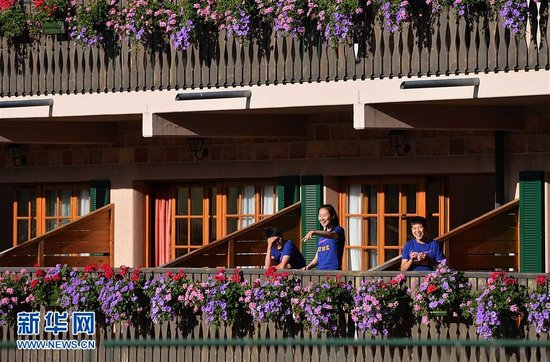 张越/7月4日，中国女足守门员张越（中）在寓所阳台上与队友谈笑。