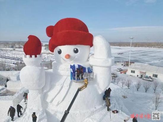 <em>哈尔滨迎来今冬首个大雪人</em>高约20米 头戴鲜红绒帽