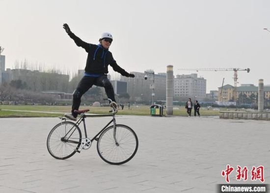 长春：花甲老人自行车上展绝技