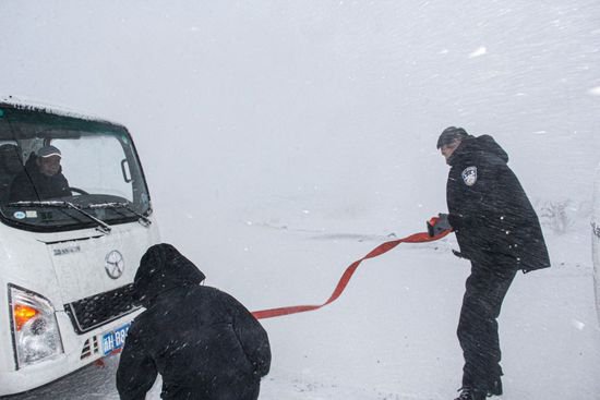 新疆阿勒泰：民警“风吹雪”中救助被困车辆
